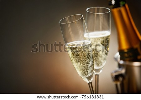 Two romantic glasses of sparkling champagne alongside a bottle in an ice bucket and copy space to celebrate a wedding, anniversary, New Year or Valentines day Stock foto © 