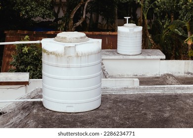 Two rooftop tanks for collecting and using water in a residential building in Southeast Asia. Water tanks on the roof are a great way to conserve water. A pump lifts water into the tank, which can the