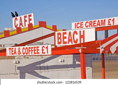 Two Rooks Bask In Winter Sunshine On Signs Advertising Summer Refreshments On The Beach Of A Deserted Holiday Resort UK