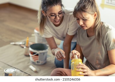 Two Roommates Preparing And Mixiig Paint To Decorate Walls In They Home.	