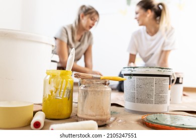  Two Roommates Preparing And Mixiig Paint To Decorate Walls In They Home.