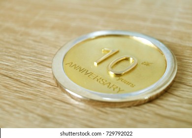 Two Round Layer Coin For 10 Years Anniversary Award On Wood Table