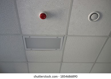 Two Round Plastic Alarm On The Gray Ceiling In The Room