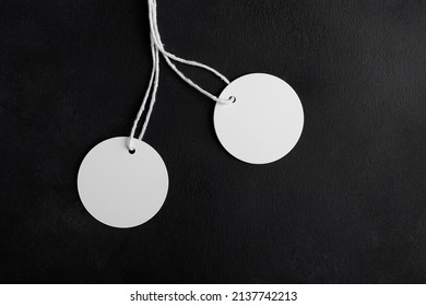 Two Round White Tag Label Mockups With White Cord On Black Background. Blank Paper Circle Price Tags Isolated, Sale And Black Friday Concept