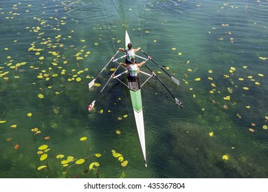 Two Rowers In A Boat, Rowing On The Tranquil Lake 