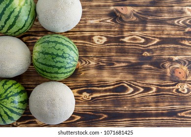 Two rows of alternating ripe melons with watermelons and cantaloupe, also known as sweet melon or spanspek, on decorative wood with copy space