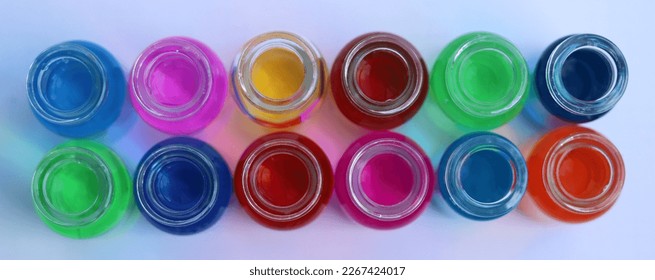 Two rows of glass jars with solutions of different colored dyes. View from above.