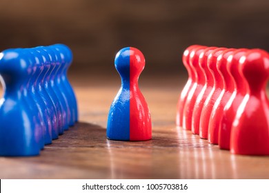 Two Rows Of Pawns Coming Together And Merging On Wooden Table