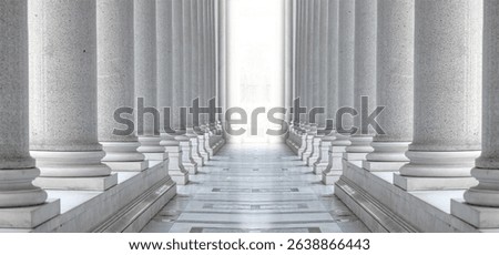 Two rows of white marble columns. Hallway with white pillars. Bright light between two rows of columns