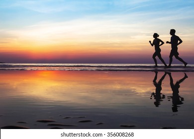 two runners on the beach, silhouette of people jogging at sunset, healthy lifestyle background with copyspace - Shutterstock ID 356008268