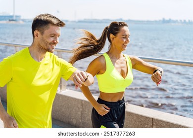 Two runners smile as they check their smartwatches during an outdoor jog along the waterfront.

 - Powered by Shutterstock