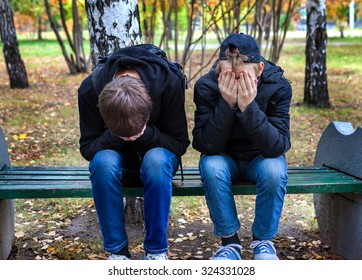 Two Sad Boys On The Bench In The Autumn Park