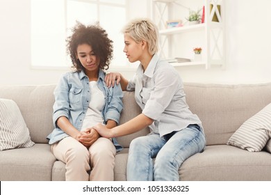 Two Sad Diverse Women Talking At Home. Female Friends Supporting Each Other. Problems, Friendship And Care Concept