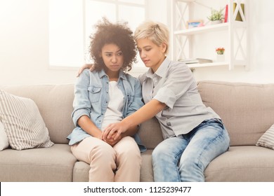 Two Sad Diverse Women Talking At Home. Female Friends Supporting Each Other. Problems, Friendship And Care Concept, Copy Space