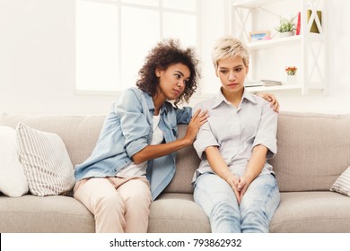 Two Sad Diverse Women Talking At Home. Female Friends Supporting Each Other. Problems, Friendship And Care Concept