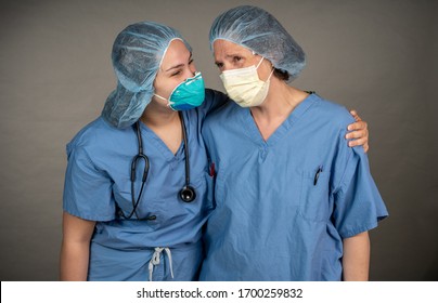 Two sad nurses consoling each other outside the OR. Medical profesisonals collaborating.