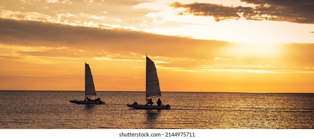 Two Sailboats In Sunset Sea