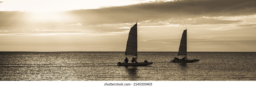 Two Sailboats In Sunset Sea