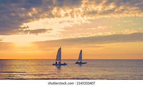 Two Sailboats In Sunset Sea