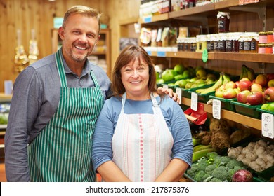 Two Sales Assistant At Vegetable Counter Of Farm Shop