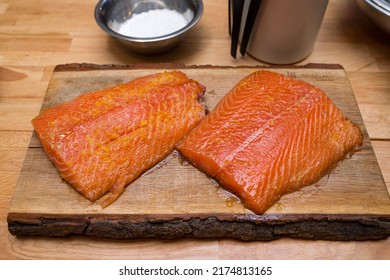 Two Salmon Fillets Marinated In Orange Pulp On A Wooden Board Before Cooking.