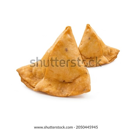 Two samosas with meat and vegetables isolated on white background. Traditional Indian food.