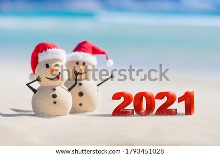 Two Sandy Christmas Snowmen are celebrating a Happy New Year on a beautiful beach with 2021 3d text, concept for new year 2021