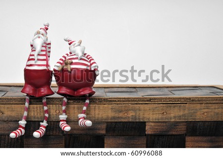 two Santa Claus are sitting on a box
