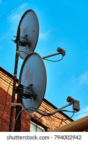Two satellite dishes installed at home looking at blue sky