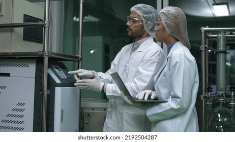 Two Scientist In Professional Uniform Working In Laboratory For Chemical And Biomedical Experiment