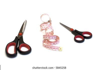 two scissors and tape measure on white background