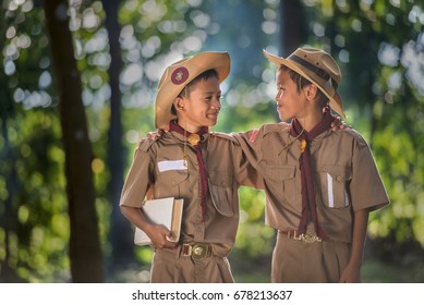 Two Scouts Are Reading A Book Scout Promise And Law In The Woods.