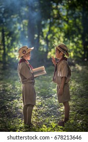 Two Scouts Are Reading A Book Scout Promise And Law In The Woods.