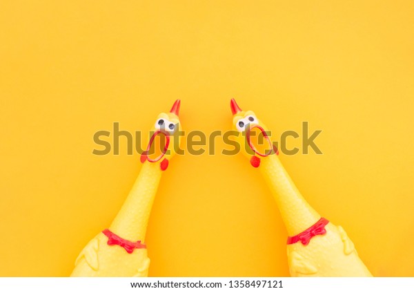 Two screaming\
chicken toys are isolated on a yellow background, screaming with a\
mouth open looking into the camera. Chicken toy on a yellow\
background, pattern for\
design.