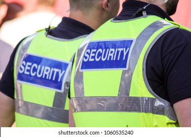 Two Security Guards On Patrol, Seen From Behind