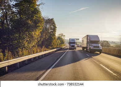 Two Semi Trucks On The Highway At Dawn