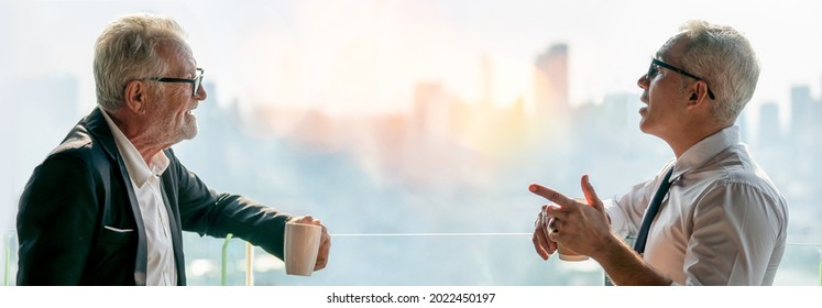 two senior businessman take a break drinking coffee and discussing business strategy in coffee shop at modern restaurant on a tall building cityscape background . old friend talking or life advice  - Powered by Shutterstock