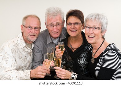 Two Senior Couples Toasting On A Happy New Year.