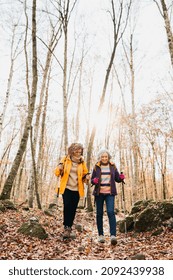 Two Senior Female Friends Hiking Together Through The Forest In Autumn