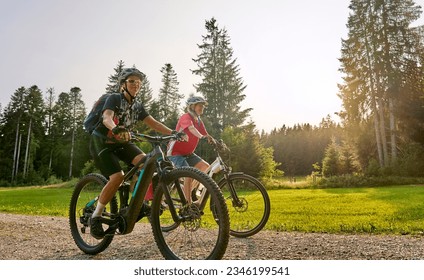 two senior girl friends having fun during a cycling tour in the Allgau Alps near Oberstaufen, Bavaria, Germany - Powered by Shutterstock