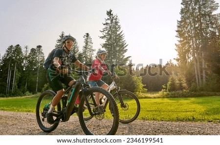 two senior girl friends having fun during a cycling tour in the Allgau Alps near Oberstaufen, Bavaria, Germany
