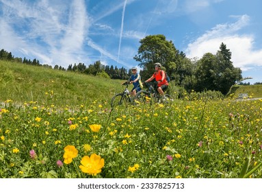 two senior girlfriends having fun during a cycling tour in the Allgau Alps near Oberstaufen, Bavaria, Germany - Powered by Shutterstock