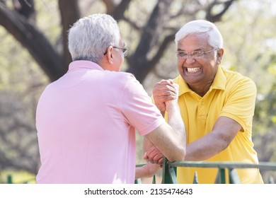 Two Senior Man Having An Arm Wrestle Competition At Park
