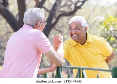 Two Senior Man Having An Arm Wrestle Competition At Park
