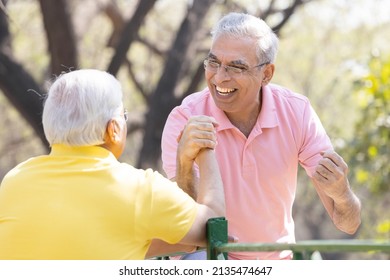 Two Senior Man Having An Arm Wrestle Competition At Park
