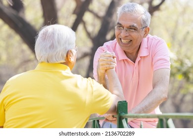 Two Senior Man Having An Arm Wrestle Competition At Park
