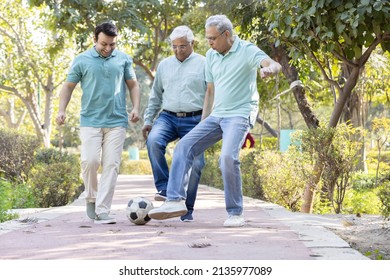 Two senior man with son having fun while playing football at park
