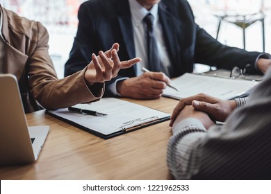 Two senior manager reading a resume during a job interview, Employer interviewing to ask young male job seeker for recruitment talking in office. - Shutterstock ID 1221962533