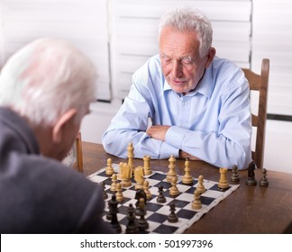 Two Senior Men Playing Chess In The Room