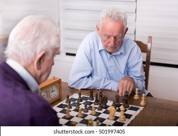 Two Senior Men Playing Chess In The Room